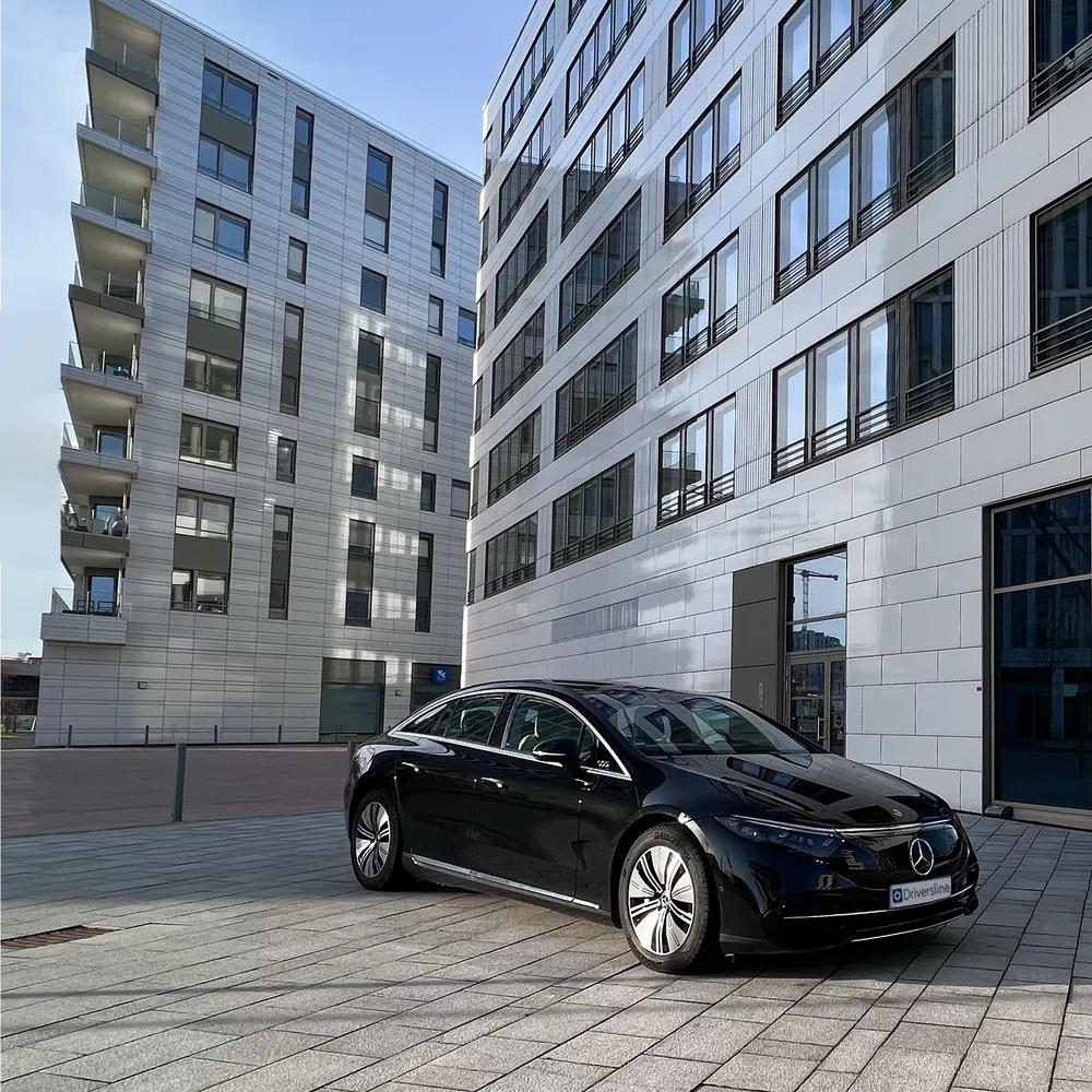 Mercedes-Benz EQS with Driversline number plate in front of a modern office facade