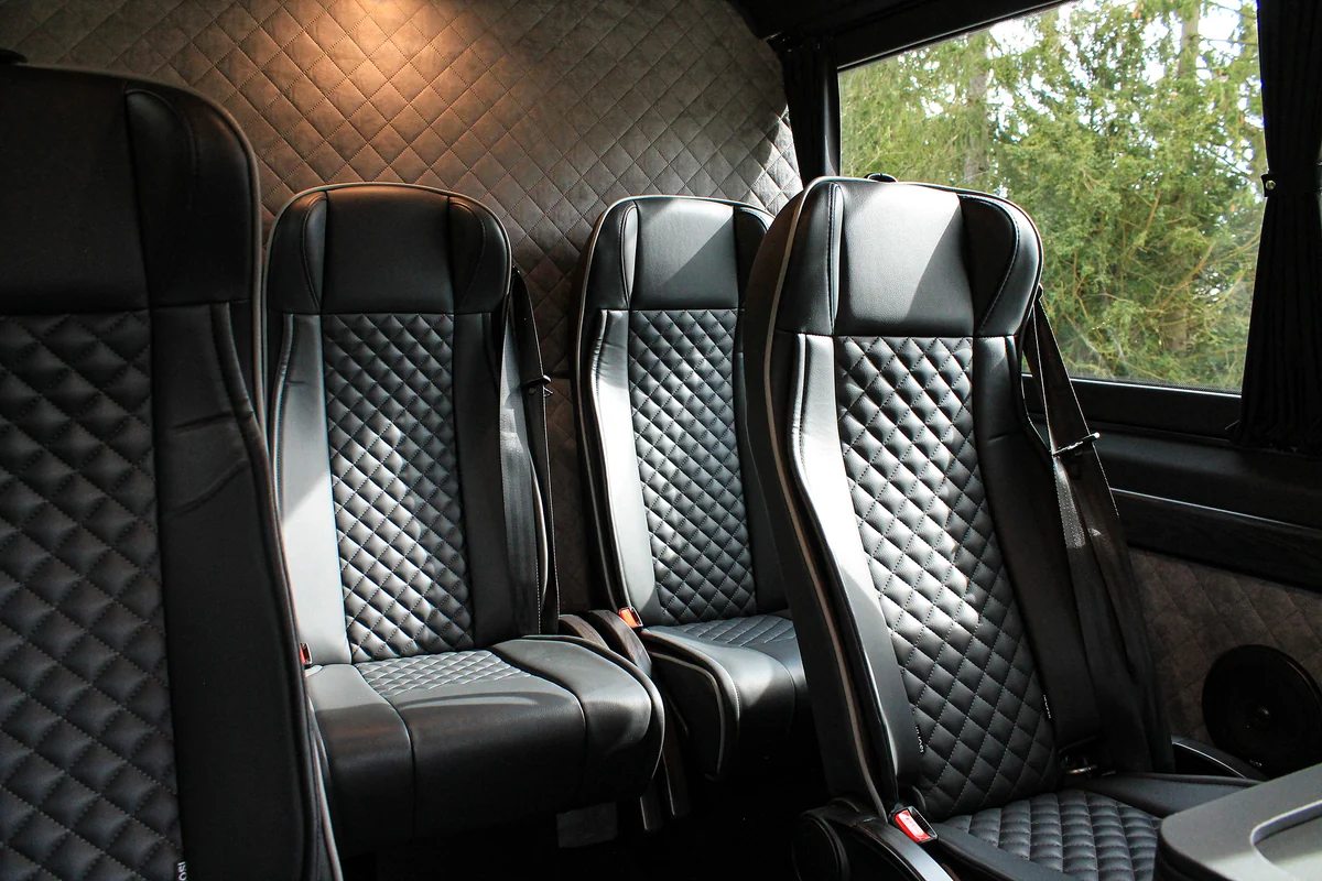 Two individual seats in the back of a VIP van with quilted leather upholstery