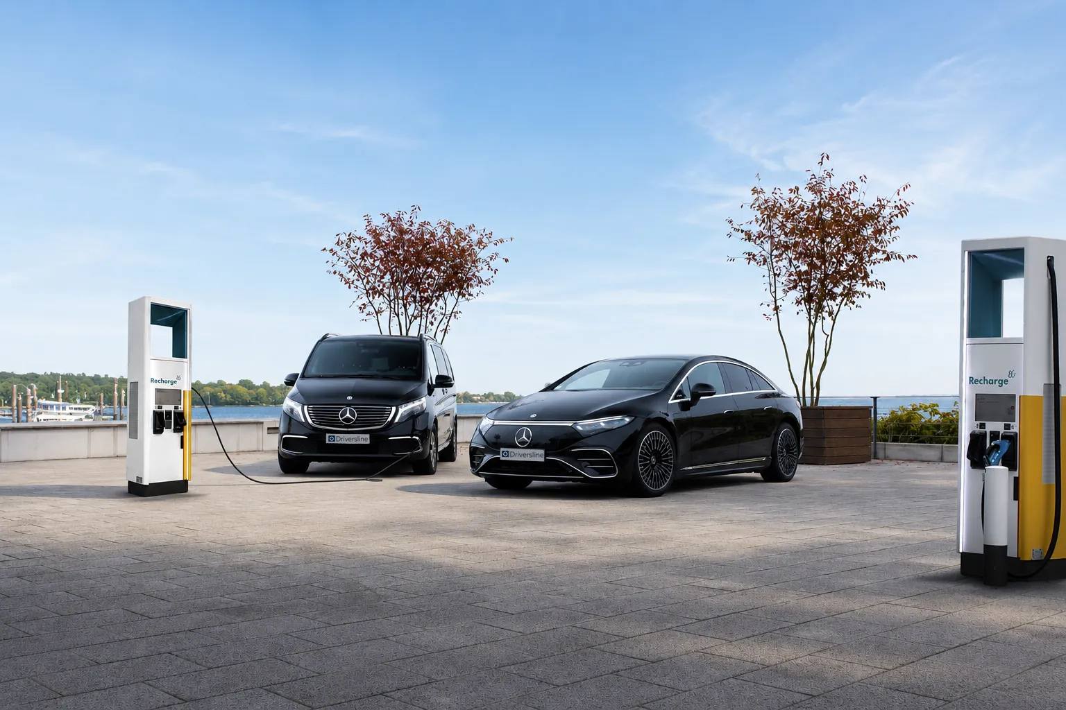 Two black Driversline electric vehicles at charging points by the water