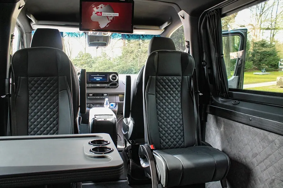 Leather-covered individual seats with a central aisle in the Mercedes-Benz Sprinter VIP