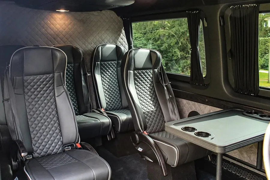 Interior of the Mercedes-Benz Sprinter VIP with table and a screen below the headlining