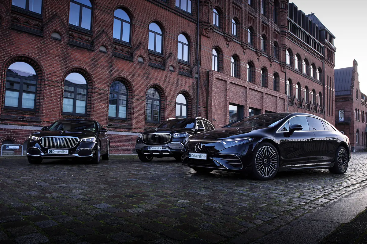 Three black Driversline vehicles side by side on cobblestones in Hamburg's Speicherstadt