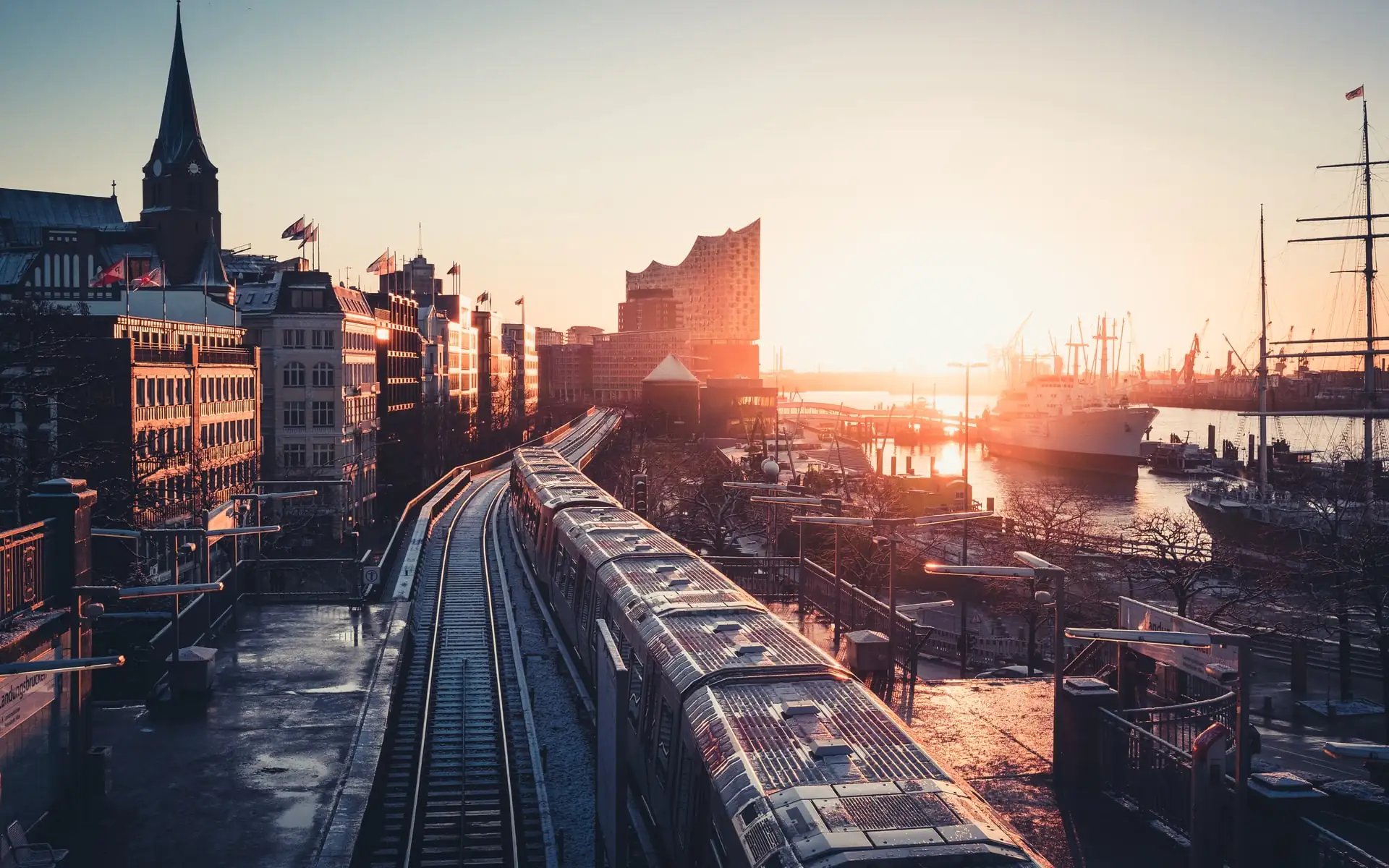 Elevated railway at the Hamburg Landungsbrücken in the evening light, with the Elbphilharmonie and the harbour behind