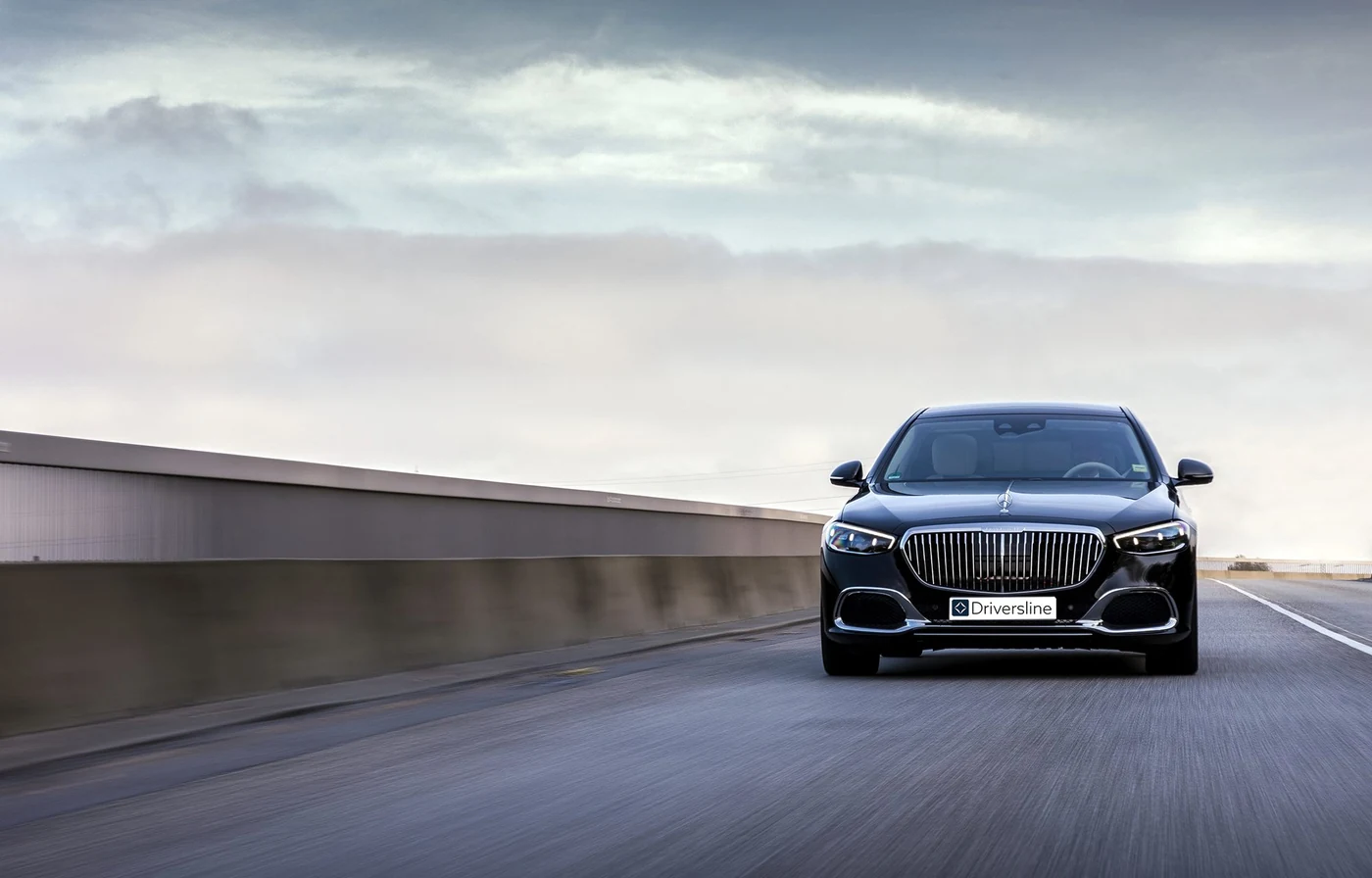 A black Mercedes-Maybach S-Class with Driversline plates on the move along an open country road