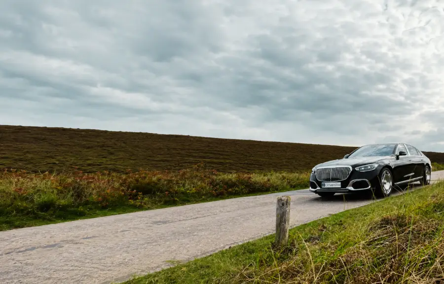 Black Mercedes-Maybach S-Class on a narrow road through the heathland of Sylt