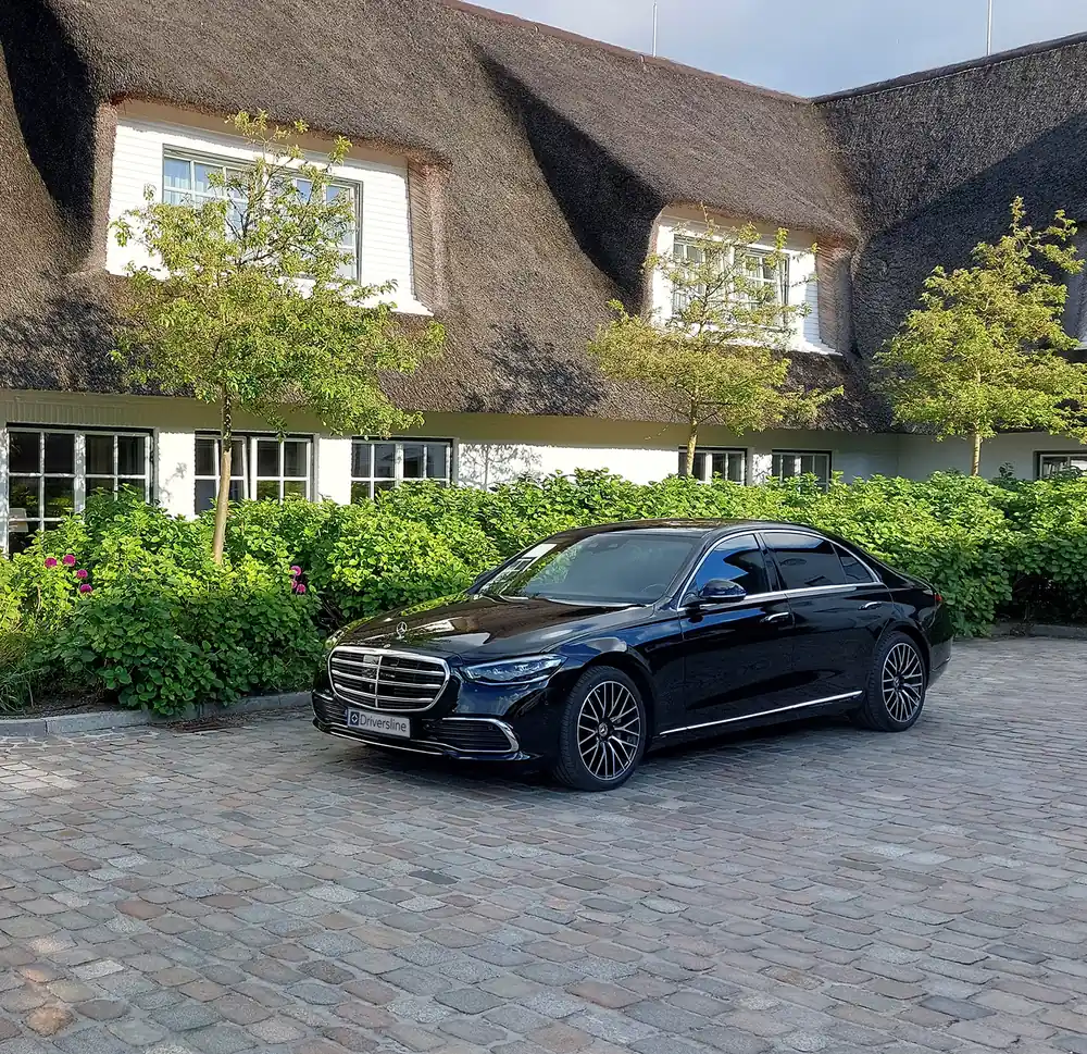 A Mercedes-Benz S-Class in front of a thatched house on Sylt